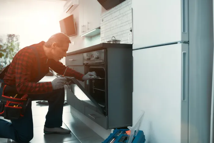 Appliance repair technician diagnosing a household fault